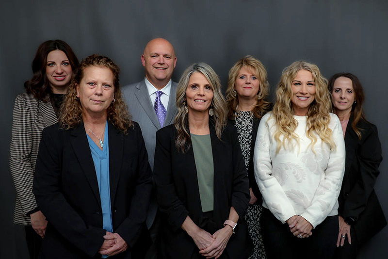 russell-county-attorney-staff Group photo of the Russell County Attorney’s Office team, including Kevin S. Shearer and staff, standing together in front of a dark gray background.